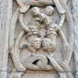 ... al lato opposto una figura maschile li raccoglie in un contenitore sul capo. Volti di nobili e religiosi si intrecciano tra le spire di un drago...